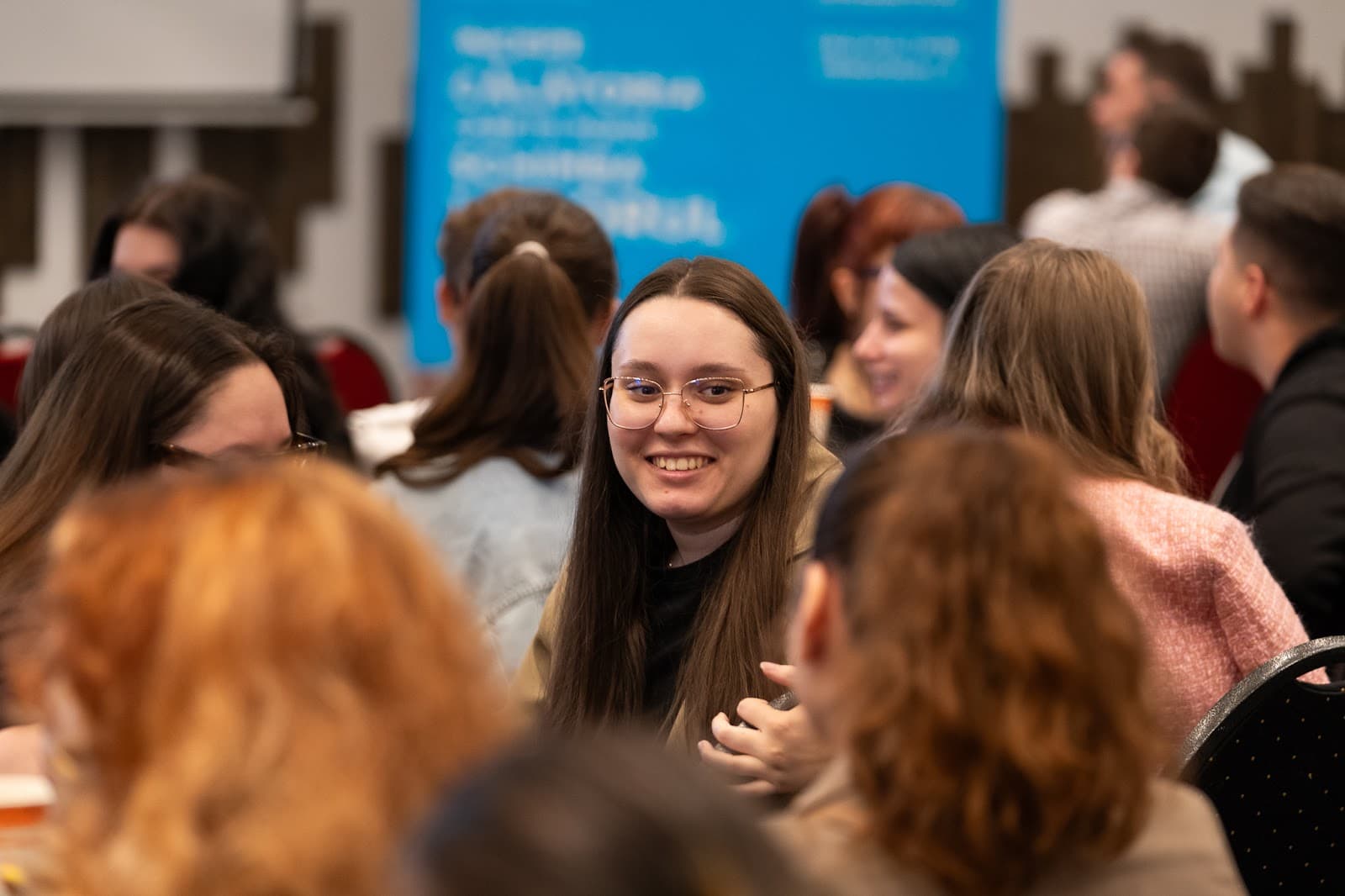 O studentă zâmbind în sală, la o întâlnire LDM la FABIZ